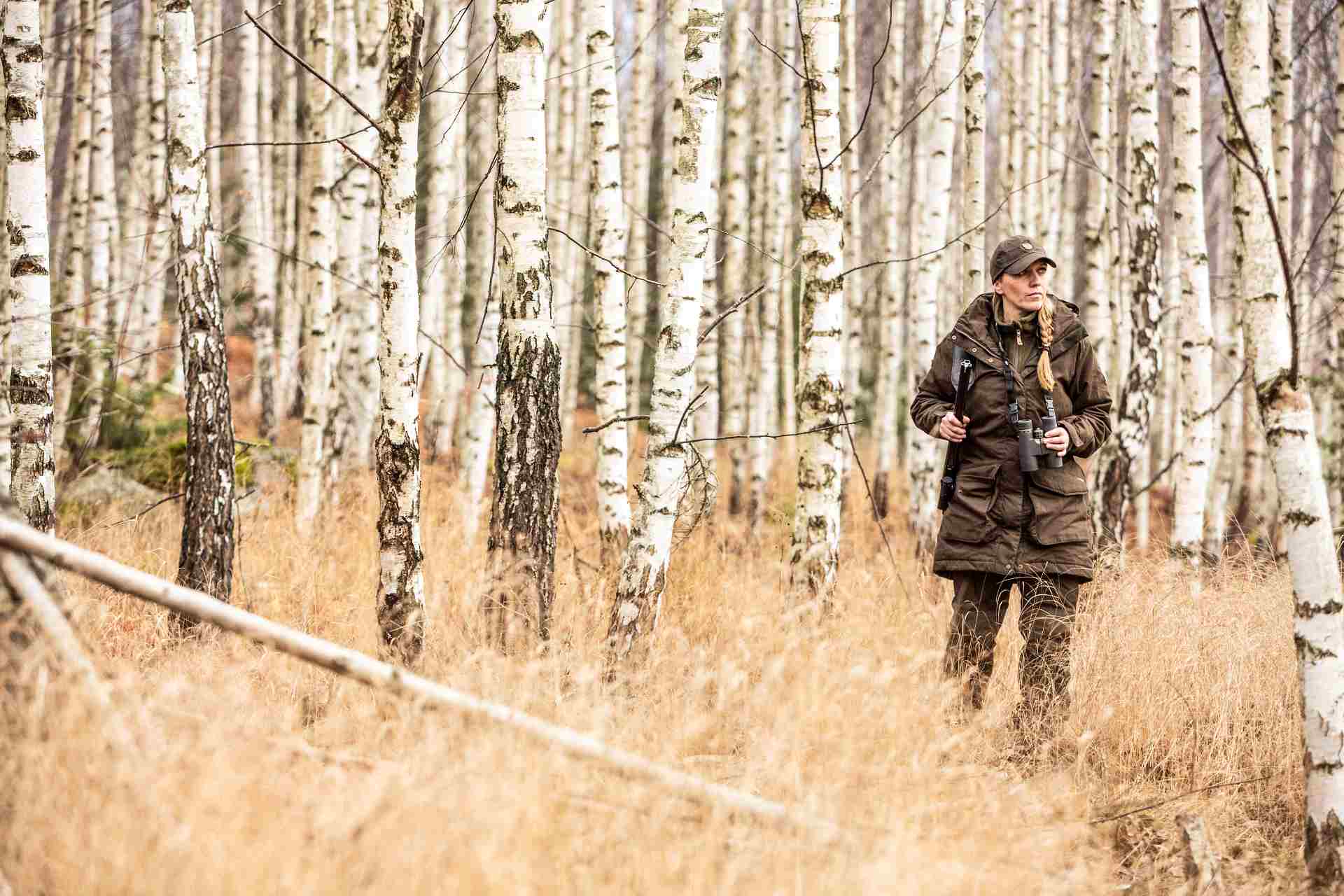 Frau bei der Jagd in Tarnkleidung im Wald