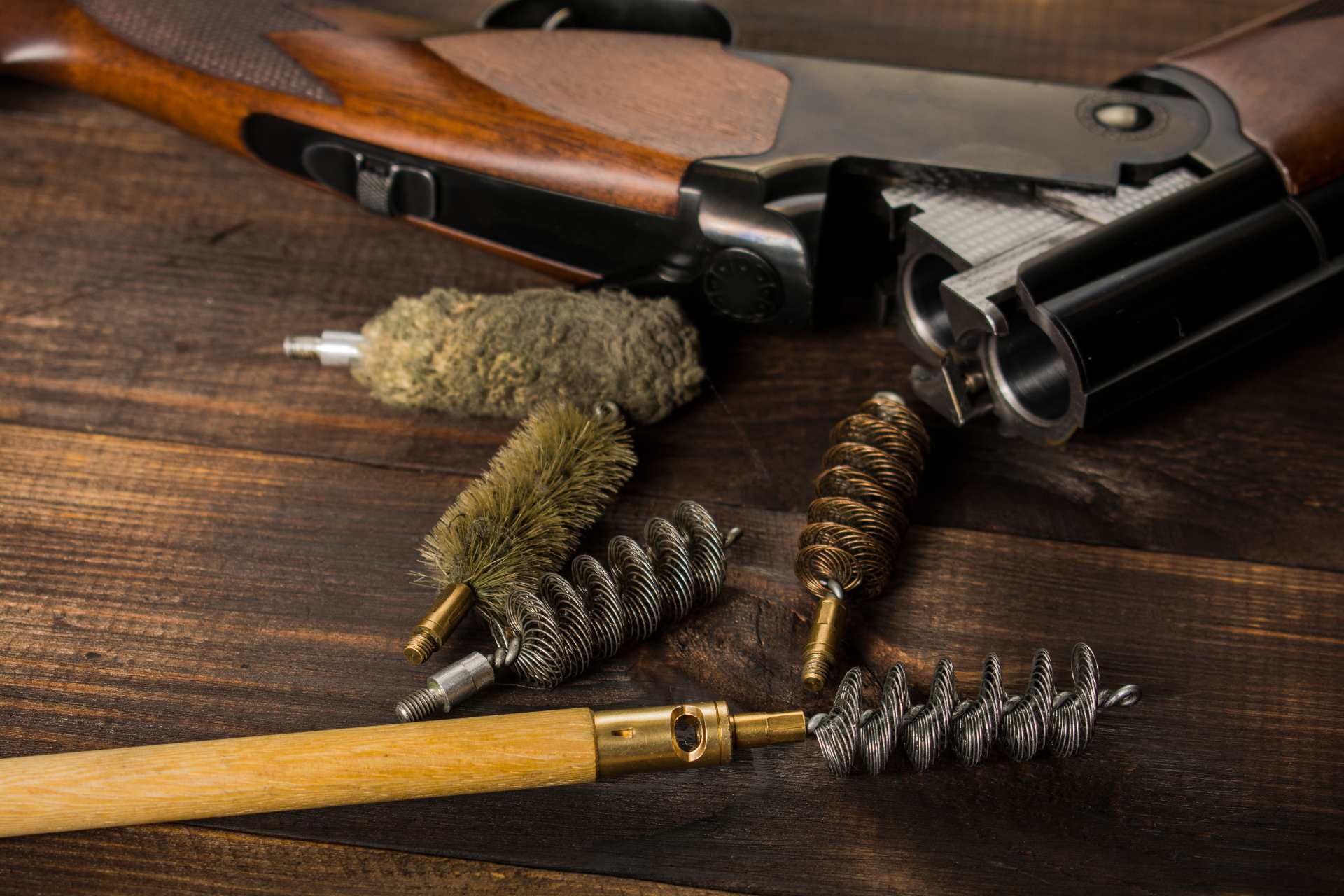 Ein Gewehr, welches gereinigt werden soll. Reinigungsutensilien liegen daneben.